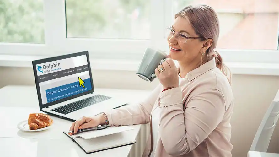 Happy woman using a laptop with a magnified screen.